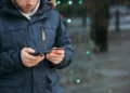 a man holding a phone and a credit card