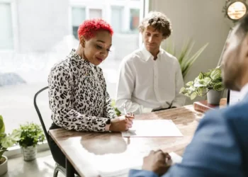 A woman is making a will with two men present in a bright office.