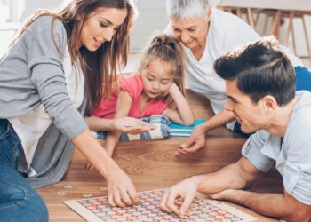 Family gathers around to play board games. Your family can save small amounts that add up fast.