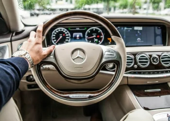 A view from the driver's seat of a luxury Mercedes steering wheel. Adopting a rich mindset can make all the difference in your savings plans.