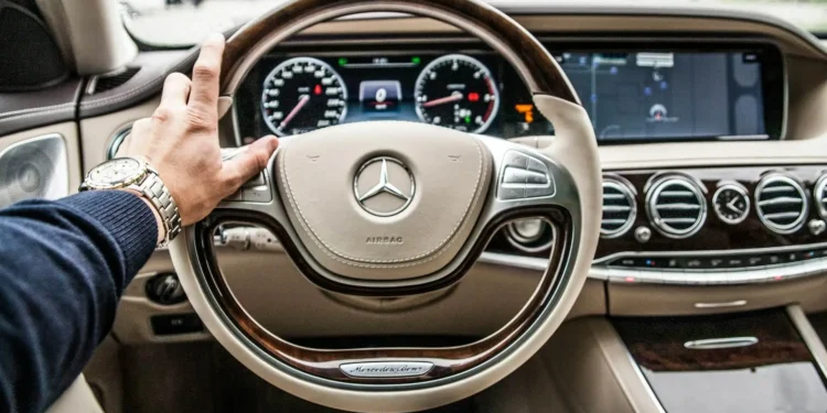 A view from the driver's seat of a luxury Mercedes steering wheel. Adopting a rich mindset can make all the difference in your savings plans.