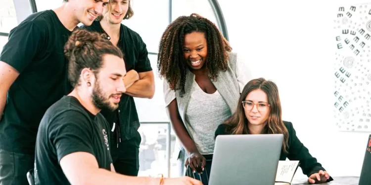 a group of millennials looking at a laptop