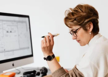 a woman holding a pen in front of a computer - is a line of credit better than a credit card?