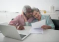 An older couple embraces while looking at paperwork. You do have options if you have no retirement savings at a later age