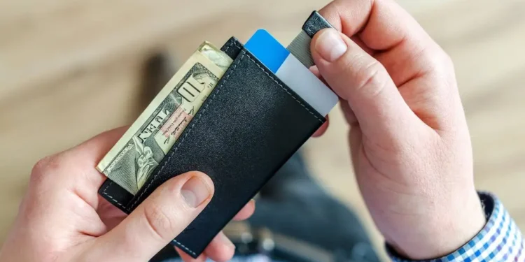 Two hands holding a black wallet. You can avoid bad credit!