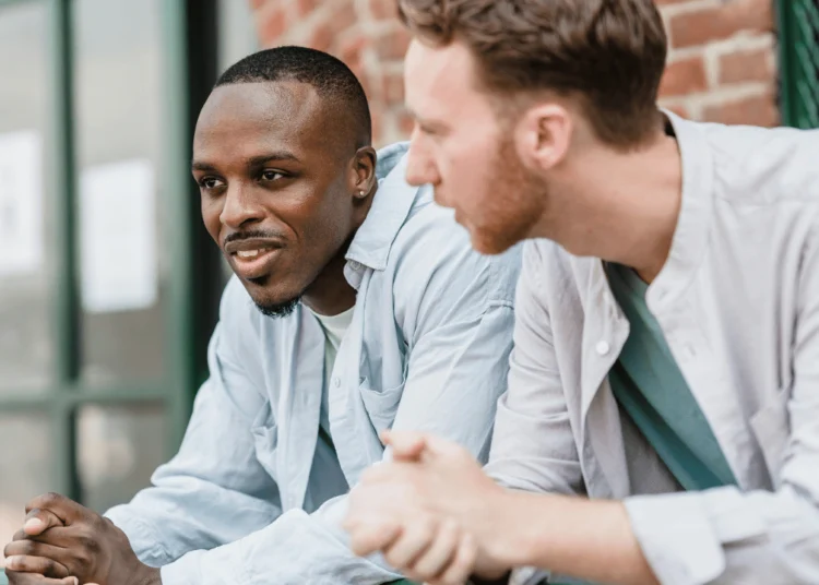 Two men sit together having the money talk.