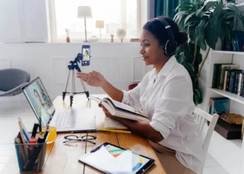 A woman wears headphones while talking to someone online. Is going back to school for your career worth it?