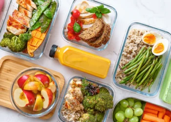 Glass dishes of fresh, healthy food are laid out in a pattern.