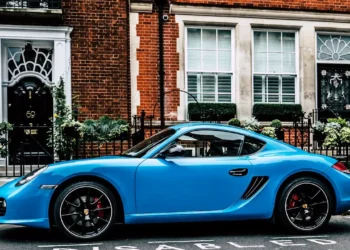 A luxurious blue sports car parked in front of a beautiful brownstone. Lifestyle inflation can really creep up on you.