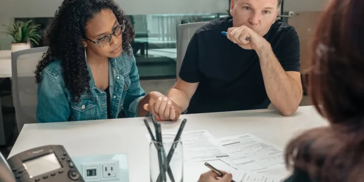 A man and woman sit across a desk from a financial advisor.