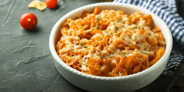 A white dish of pumpkin and sausage pasta bake.