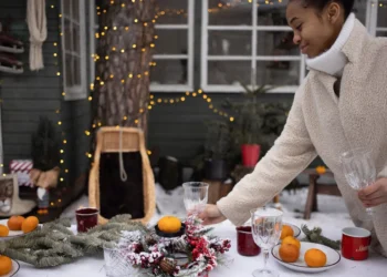 A woman getting ready for the holidays by decorating a table.