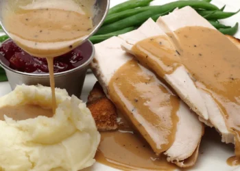 A Thanksgiving feast of turkey breast, mashed potatoes and gravy and green beans.