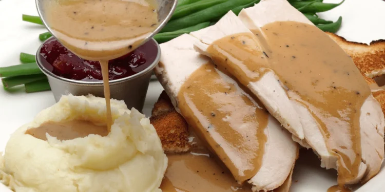 A Thanksgiving feast of turkey breast, mashed potatoes and gravy and green beans.