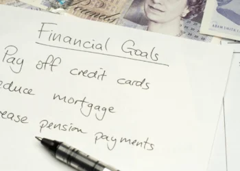 Papers on a desk from someone setting financial goals.
