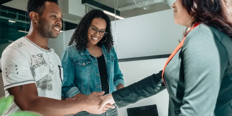 Man and woman shake hands with a financial advisor