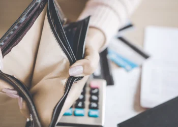 Two manicured hands hold open an empty wallet. Hardship loans are one way to go when you're in a tough financial situation.
