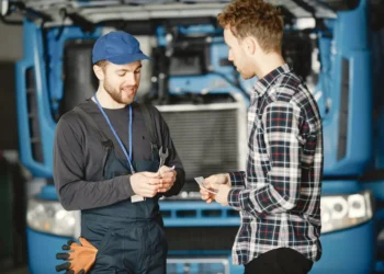 Two men exchange money behind a blue van. Social capital can save you money and help you gain knowledge.