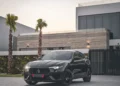 Luxury vehicle parked in front of a modern mansion. Do you have a wealth mindset?