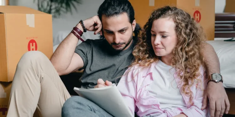Man and woman sit together looking at a notebook. What's the difference between a traditional IRA vs Roth IRA?
