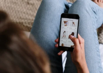 Woman holds phone while she online shops.