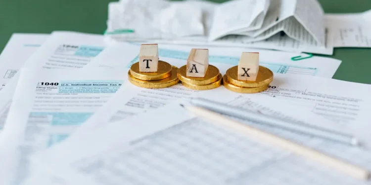 TAX spelled out in wooden blocks on a table. Tax season tips to help you!