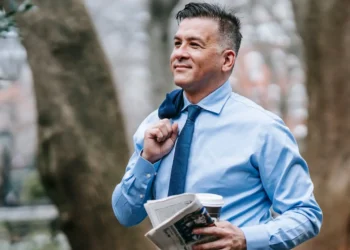 Man walks in park with newspaper. Solo finances mean you're in control.