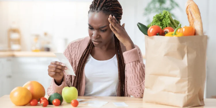 Woman looks at a grocery bill after new tariffs.