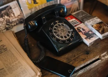 1970s style telephone and cassette tapes on a table.