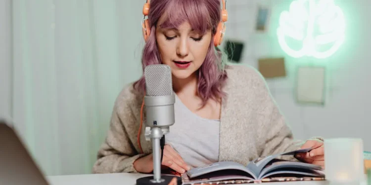 Woman speaks into a microphone. These financial literacy podcasts are not to be missed!