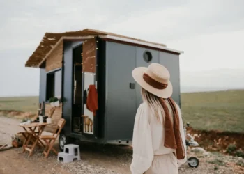 Woman walks toward a tiny house. Alternative housing options are out there.