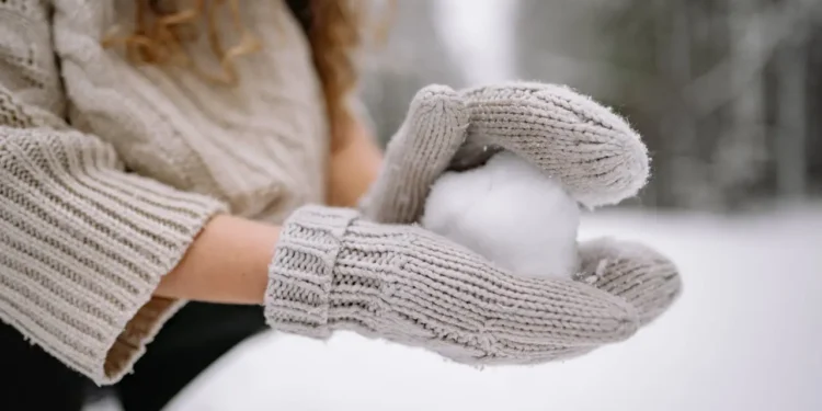 Someone holds a debt snowball in her mittens.