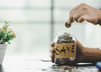 Person puts coins in a jar marked SAVE. You can maximize your money with every decision.