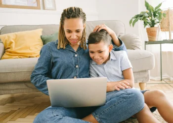 Mom and child look at a laptop together. What lessons do rich people teach their kids to get them ahead?