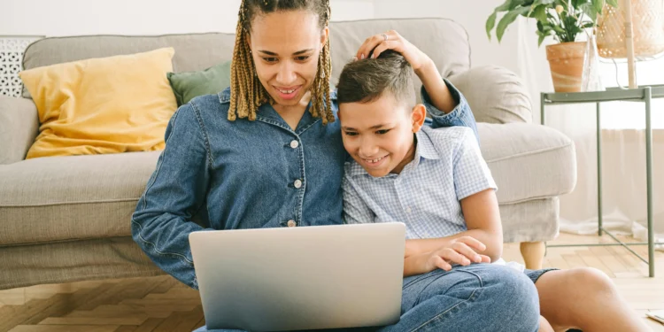 Mom and child look at a laptop together. What lessons do rich people teach their kids to get them ahead?