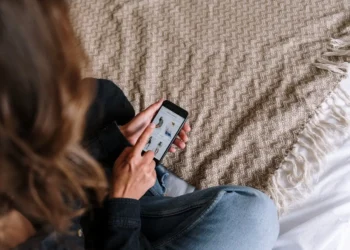 Woman looks at her phone. Managing your email lists can save you a bundle.