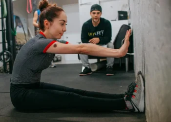 Young woman works out with a trainer. Should you spend or splurge on fitness memberships.