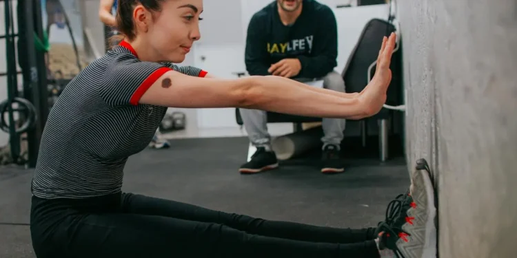 Young woman works out with a trainer. Should you spend or splurge on fitness memberships.
