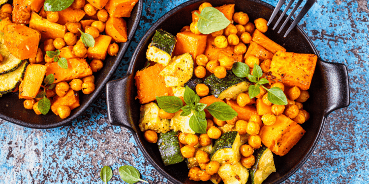 A pan of Spiced Chickpea and Sweet Potato Salad on a blue background.