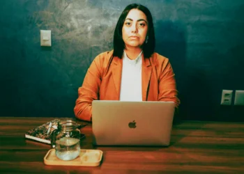Professional woman sits at a desk in front of laptop.