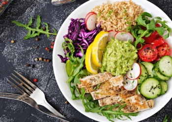 A bowl of protein-packed veggie salad with chicken and quinoa.