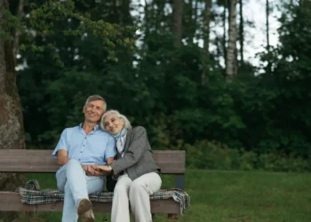A retired couple rests on a bench together. What's the true cost of retirement?