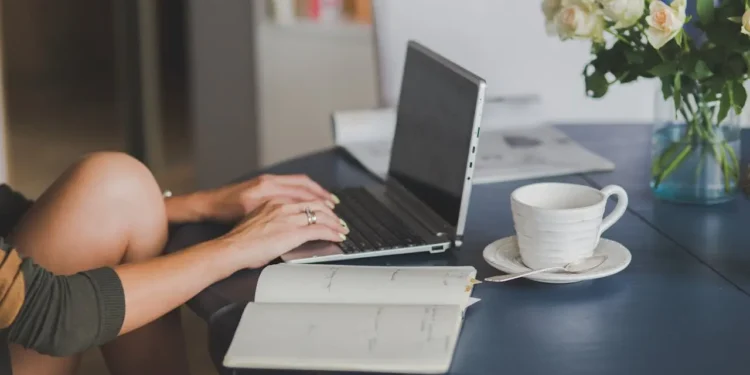 Hands lay on a laptop keyboard on a desk. Investing in your freelance business will pay off.