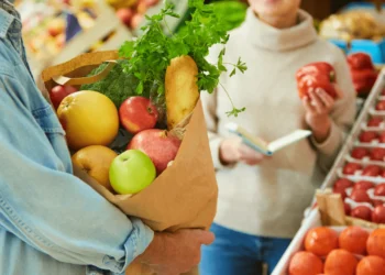 Person holds a bag of groceries in a store.