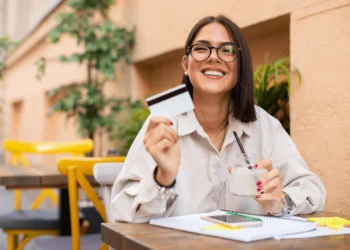 Young woman holds up line of credit card.